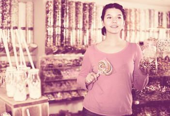 Girl choosing sweets in shop