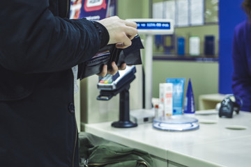 close up person paying cash in the store with wallet
