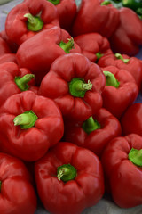 Red bell peppers stacked at farmers market.