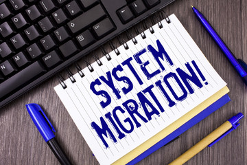 Word writing text System Migration Motivational Call. Business concept for Moving programs to another platform written on Notepad on wooden grey background Pens and Black Keyboard next to it.