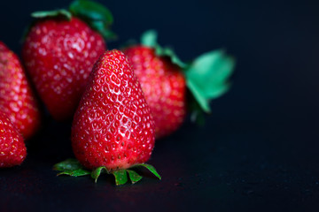 Ripe strawberries on a dark background.