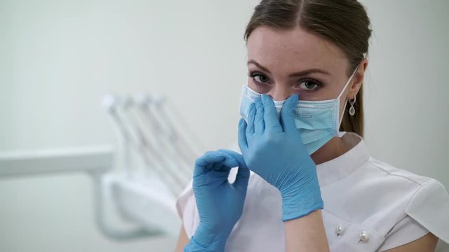Dentist doctor in dental clinic put on face mask and smiling