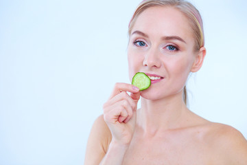 Young beautiful woman with cucumber slices on white background.