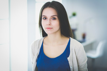 Attractive young woman standing in white studio