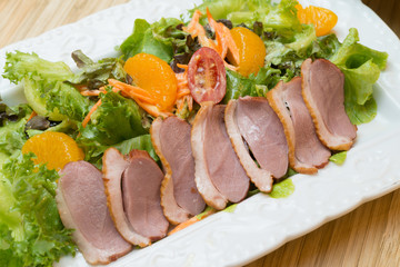 fresh vegetable salad with duck breast and orange.