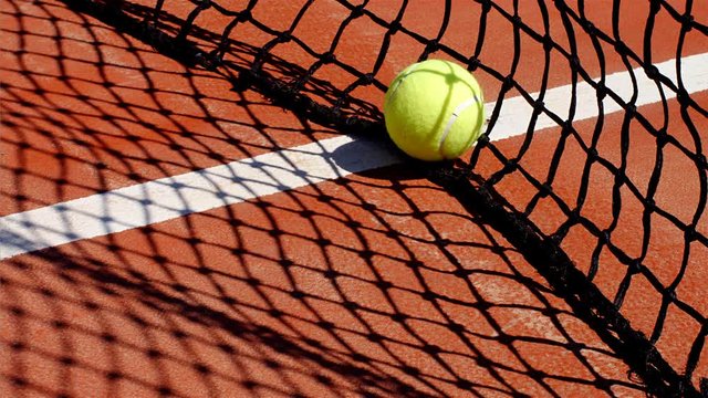 Slow motion of a tennis ball rolling towards the net, 4k