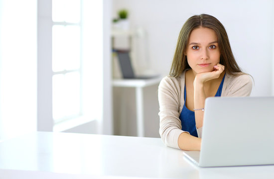 Beautiful young woman using laptop computer at the desk
