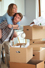 Fototapeta na wymiar Couple unpacking cardboard boxes in their new home. Young couple.