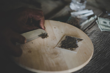 Fototapeta na wymiar Man cutting marijuana on a Chopping board