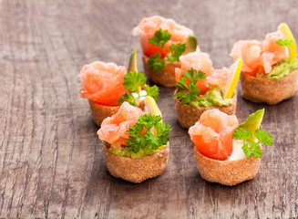 Croustades  crispy pastry cases filled with salted salmon and avocado on wooden table