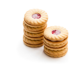 Stacked  shortcake biscuits sandwiched with cream and jam isolated on white
