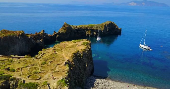 Aerial view of a beach with Italian sea and its green and lush vegetation along the coast. Concept of: aerial, vacation, italian, sea