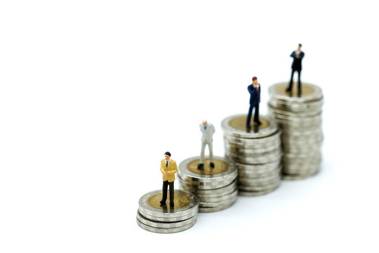 Miniature people : Businessman standing with wooden bar chart icon and stack of coins,Business Vision Concept.