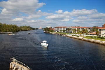Obraz premium Boat Approaches the Intracoastal Waterway Bridge Just North of Hillsboro Blvd. in a Bright Sunny Afternoon with the Boca Hotel and Resort in the Background