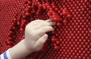 children's hands and pinskreen. the child is playing with the contact screen. children's hands are pressed onto the plastic pins on the interactive panel and leave prints.