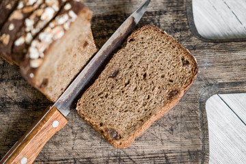 Pieces, slices of sliced rye bread with raisins on wooden Board, rustic background vintage, healthy natural food concept
