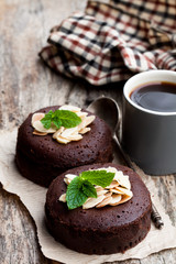 Chocolate  fondant with almonds and cup of coffee on wooden table