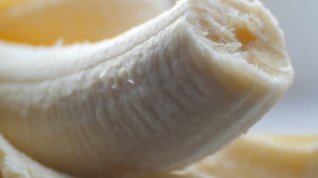 Bitten body banana with the peel on a white background macro close up view