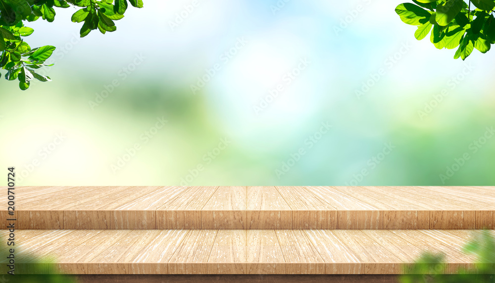 Aufkleber Empty step plank wood table top with blur tree in park with bokeh light background and leaves foreground,Mock up template for display of your design,Banner for advertise of product,panorama view