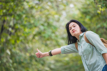 Asian woman backpacker standing on countryside road with tree in spring seasonal,Alone travel or single traveller concept