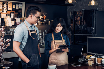 Asia Barista waiter take order from customer in coffee shop,cafe owner writing drink order at counter bar,Food and drink business concept,Service mind concept.restaurant worker.