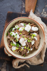 Above view of rye dumplings stuffed with sauerkraut and topped with fresh green onion and sour cream