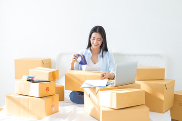 Fototapeta na wymiar Young asian woman business owner work and white down address for deliver at home, woman business owner concept, 20-25 year old.