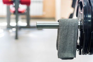 Grey towel hangs on barbell in gym