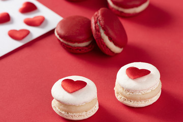 red hearts with French red macaron on red background, love concept