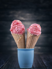 strawberry ice cream in waffer on wooden background