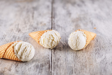 Vanilla ice cream with cone on wooden background background