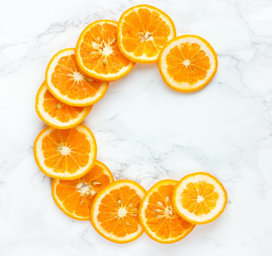 Orange slices vitamin c letter on white background