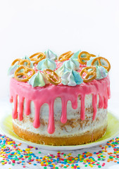 Birthday cake decorated with pink icing, meringue, sprinkle