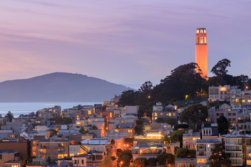Coit Tower lit orange in recognition of the San Francisco Giants. Taken from a downtown building rooftop. San Francisco, California, USA.