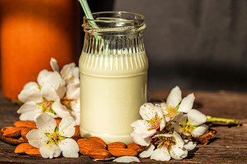 Fototapeta na wymiar Almond with jar of almond milk and white flowers