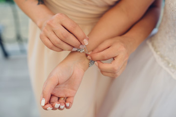 Close friends of the bride helps her dress