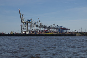 Fototapeta premium Kräne am Fluss Elbe im Industriehafen von Hamburg in Deutschland