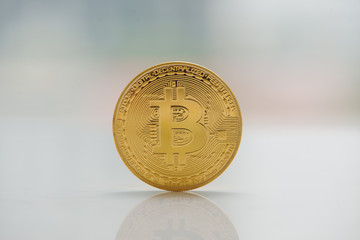 Digital currency physical gold bitcoin coin on the table near window