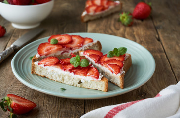Toasts with ricotta cheese and strawberries on a plate