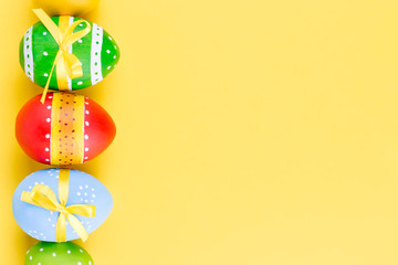 Colorful easter eggs on yellow background flat lay.