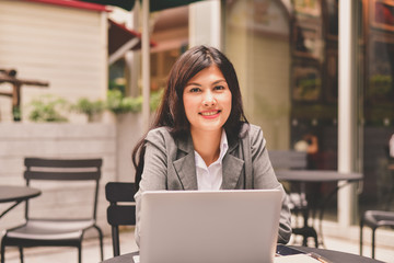 Obraz na płótnie Canvas Business Concept.Young Asian businesswoman is working happily.Young businesswoman working in a cafe.Young businesswoman is relaxation in a coffee shop.