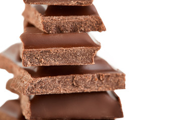 Milk chocolate pieces isolated on white background.