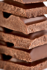 Milk chocolate pieces isolated on white background.