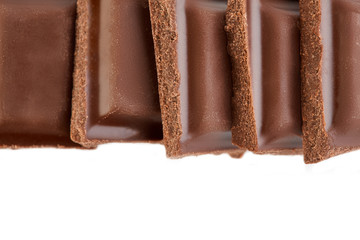 Milk chocolate pieces isolated on white background.