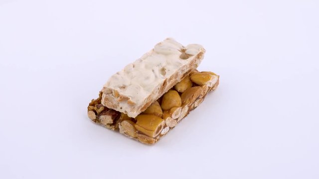 Turron - traditional dessert in Spain rotating on white turn table. Isolated on white background. Loopable. Close up macro.