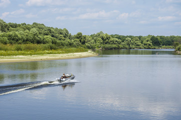 Fototapeta na wymiar a fisherman on a motor boat rides the river