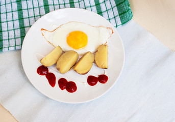 Fried egg. Plate, assortment of sauces, potato. Textile, copy space.Candid.