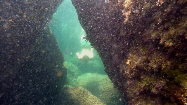 A man swims in an underwater cave