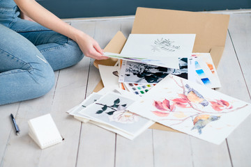 Fototapeta premium creative art lifestyle. drawing hobby and self expression. woman looking through paintings at home