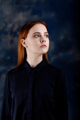 Portrait of a young longhair girl looking away on blurred dark blue background
